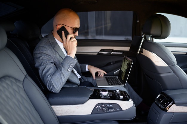 handsome-businessman-using-his-mobile-phone-modern-car-with-driver-center-city-concept-business_209729-327.jpg